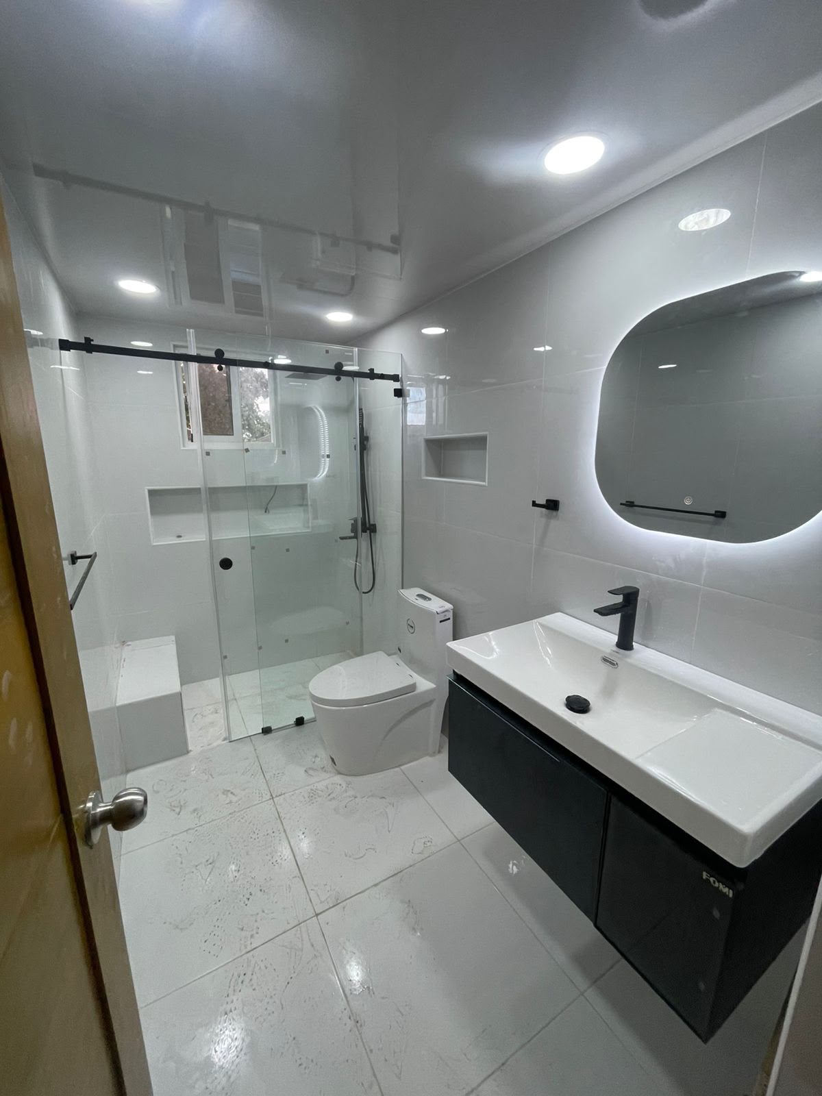 Mampara corrediza en baño blanco y negro