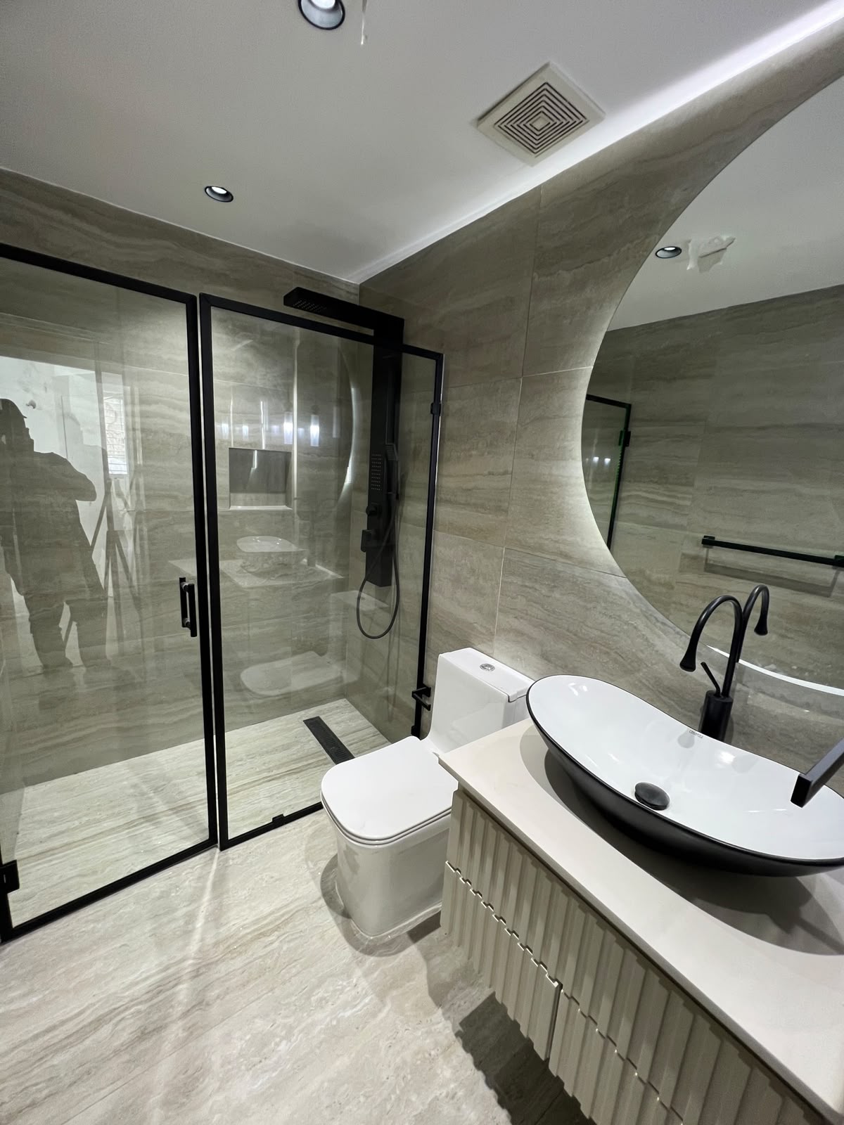 Baño en travertino con grifería negra